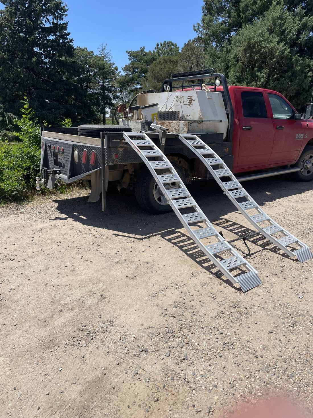 Hitch-mounted ramps deployed off a flatbed truck
