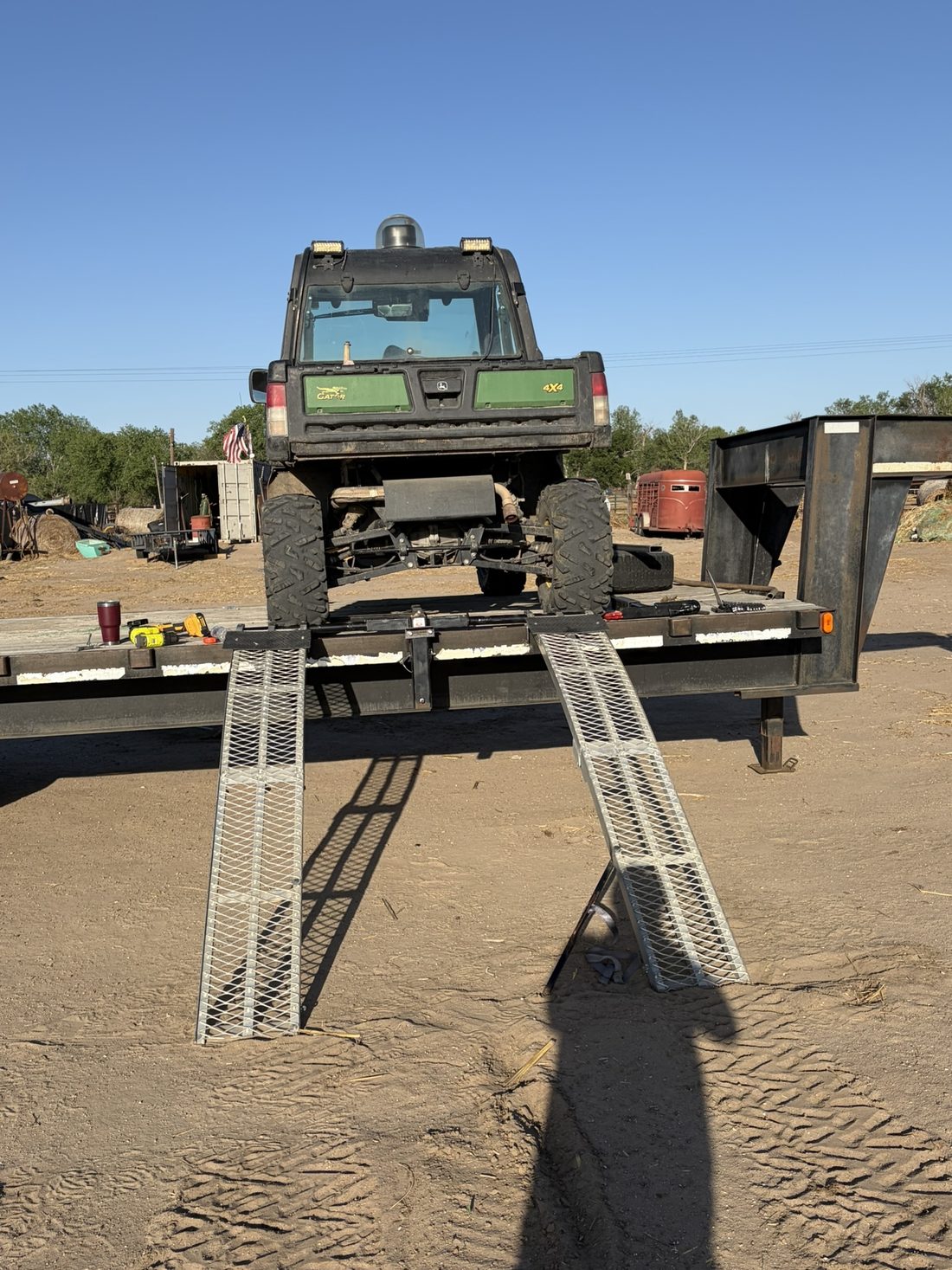 Side-by-side loaded on a flatbed with ramps deployed