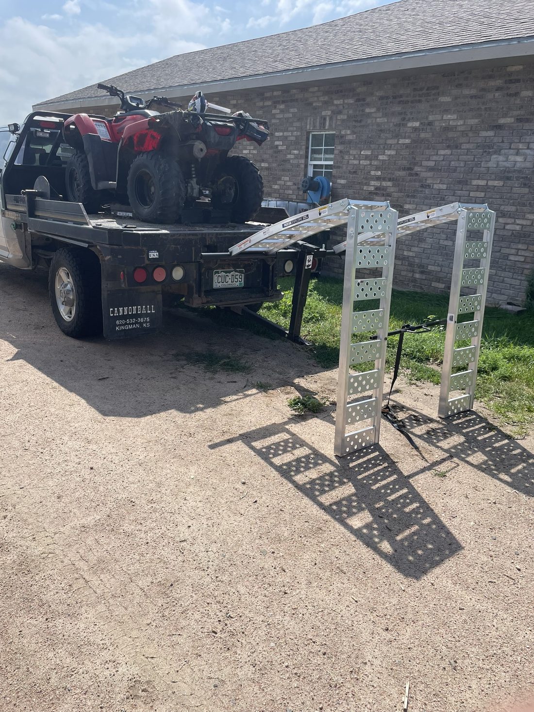 ATV loaded on a flatbed with the folding ramps beside